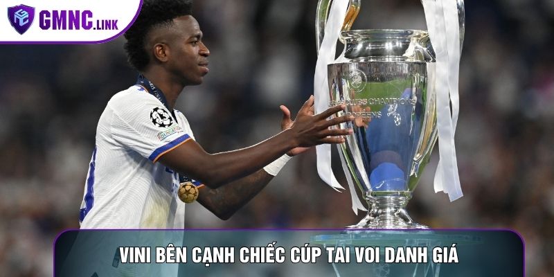 Vini bên cạnh chiếc cúp tai voi danh giá